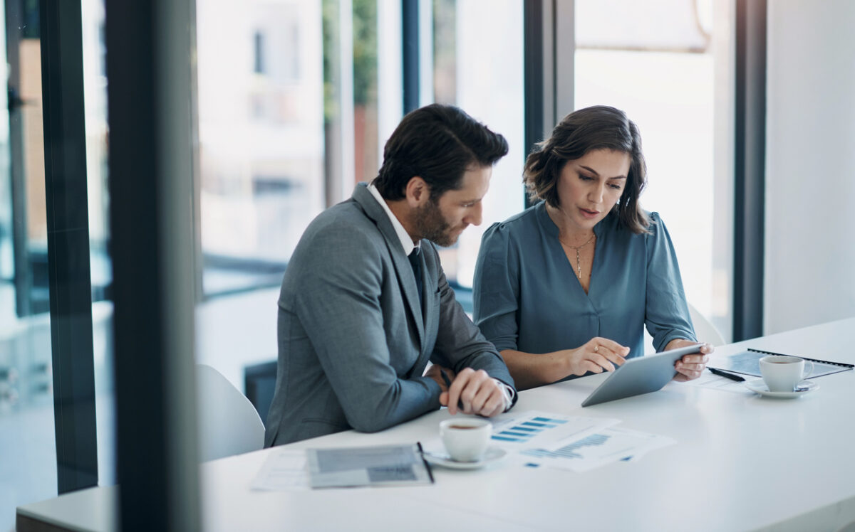 Business people, teamwork and tablet for statistics, finance report and planning of revenue, profit or sales in office. Professional advisor or clients with data analytics, graphs and digital charts