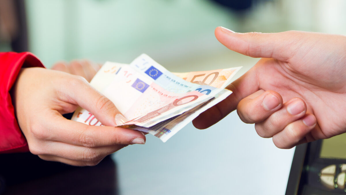 Portrait of woman customer paying with money. Hands detail.