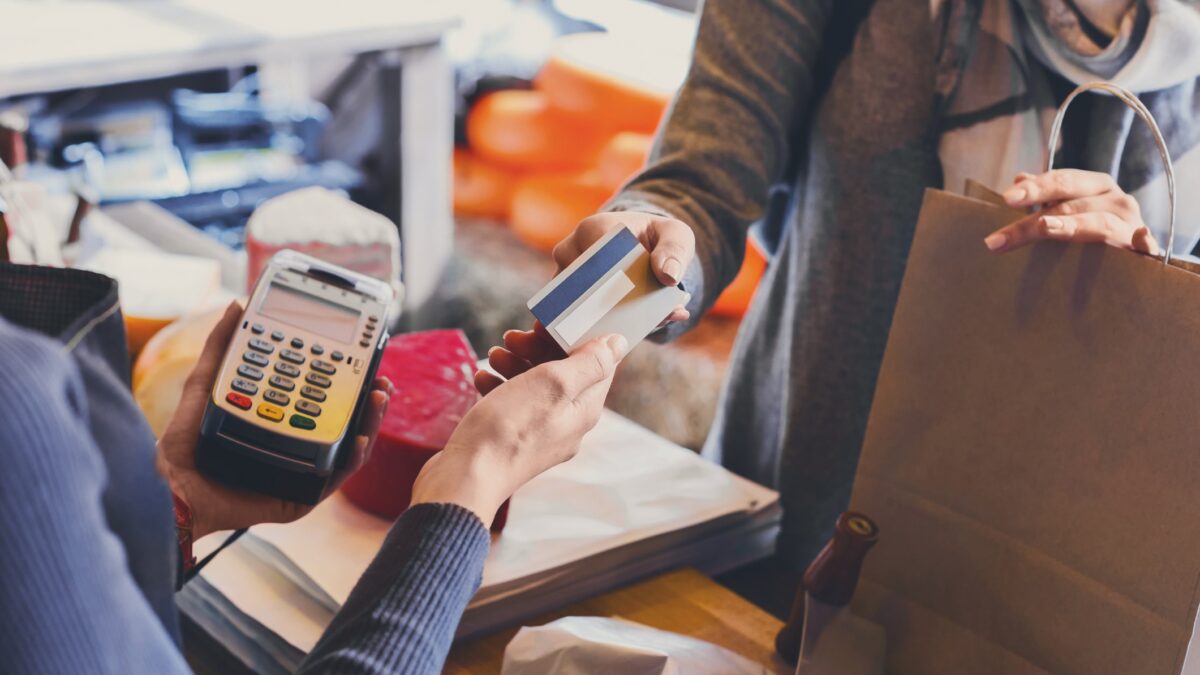 Retail, credit card payment service. Customer paying for order of cheese in grocery shop.