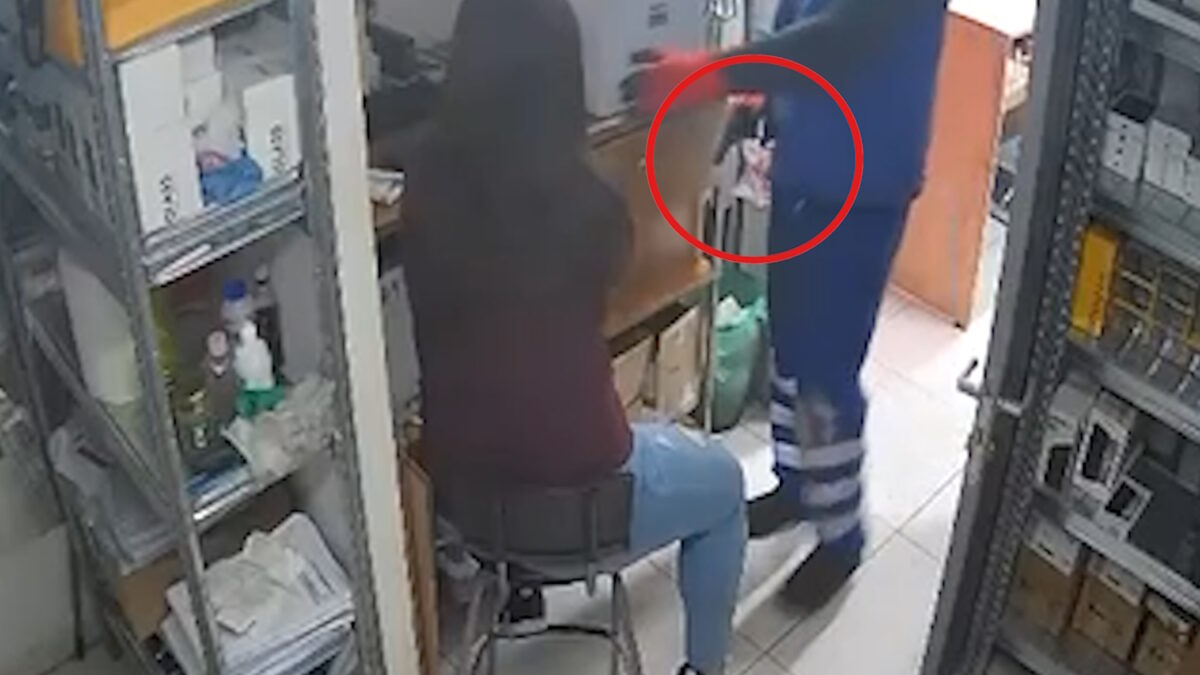 Ο ληστής με το πιστόλι δίπλα στην εργαζόμενη του καταστήματος