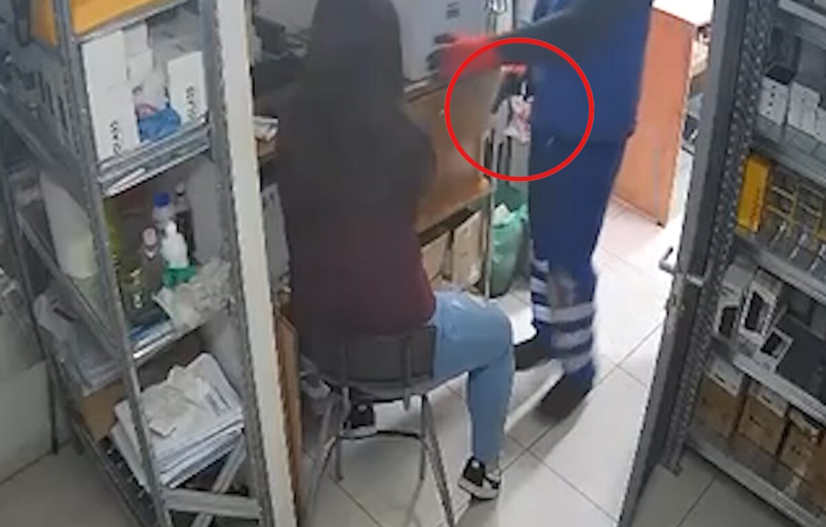 Ο ληστής με το πιστόλι δίπλα στην εργαζόμενη του καταστήματος