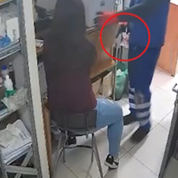 Ο ληστής με το πιστόλι δίπλα στην εργαζόμενη του καταστήματος
