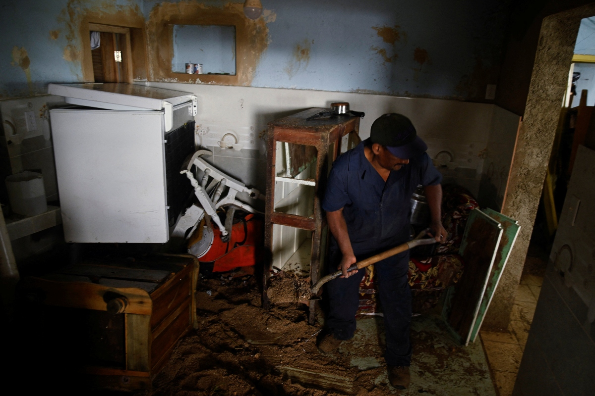 Ανδρας καθαρίζει λάσπες και νερά από το σπίτι του