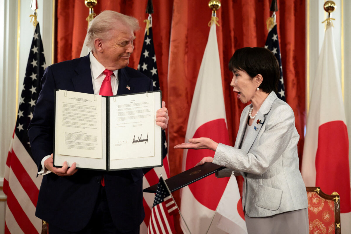 Japanese Prime Minister Sanae Takaichi reacts as U.S. President Donald Trump holds up a signed document regarding securing the supply of critical minerals and rare earths, at a bilateral meeting at Akasaka Palace in Tokyo