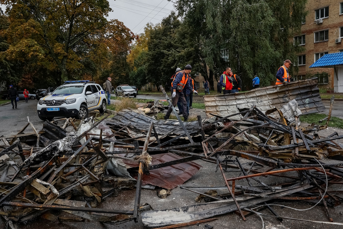 Municipal employees clean the debris near buildings that have suffered damage during a Russian attack with drones and rockets in Ukraine