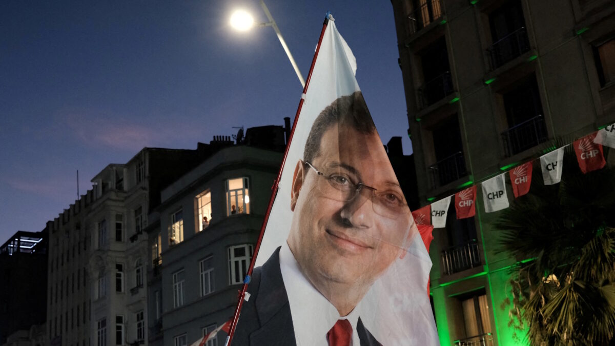 Υποστηρικτές του Εκρέμ Ιμάμογλου κρατούν σημαία με το πρόσωπό του