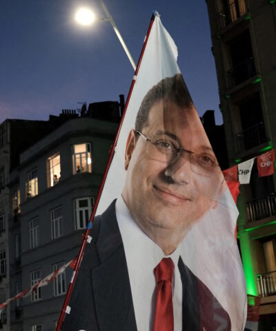 Υποστηρικτές του Εκρέμ Ιμάμογλου κρατούν σημαία με το πρόσωπό του