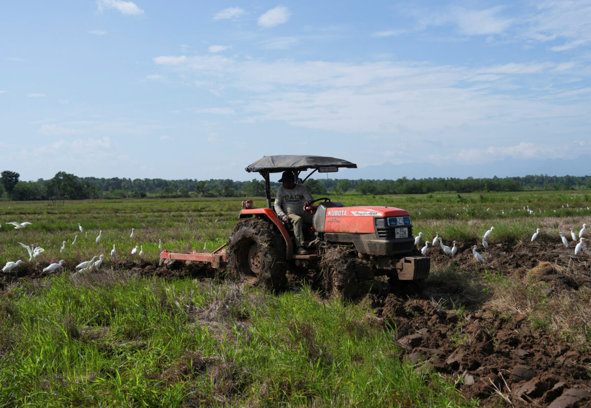 Ένας αγρότης σε τρακτέρ οργώνει χωράφι