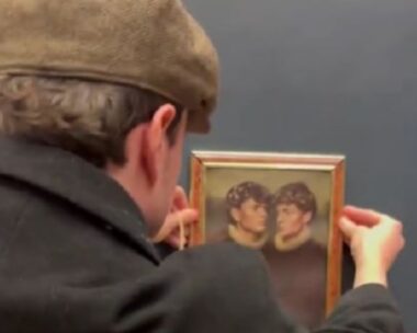 Άνδρας κρεμάει πίνακα σε τοίχο