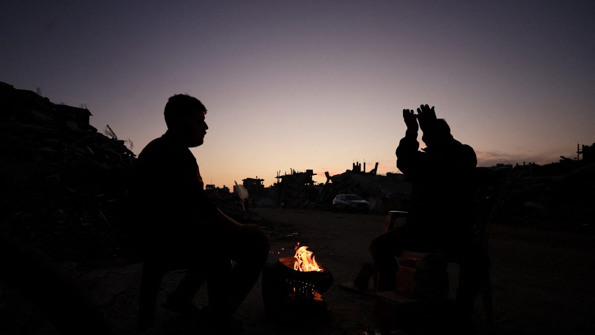 Παλαιστίνιοι ζεσταίνονται δίπλα σε φωτιά στη Γάζα