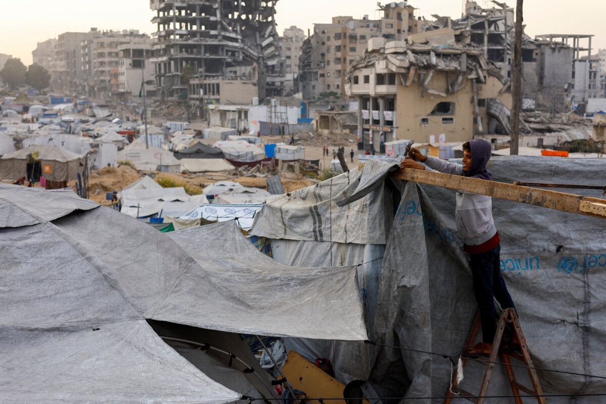 A displaced Palestinian fixes a tent, amid a ceasefire between Israel and Hamas, in Gaza City, November 4, 2025. REUTERS