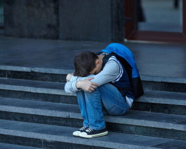 Schoolboy crying in the yard of the school. Negative emotion.