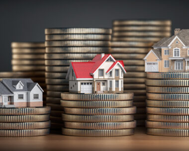 Houses of different size with different value on stacks of coins. Concept of property, mortgage and real estate investment. 3d illustration