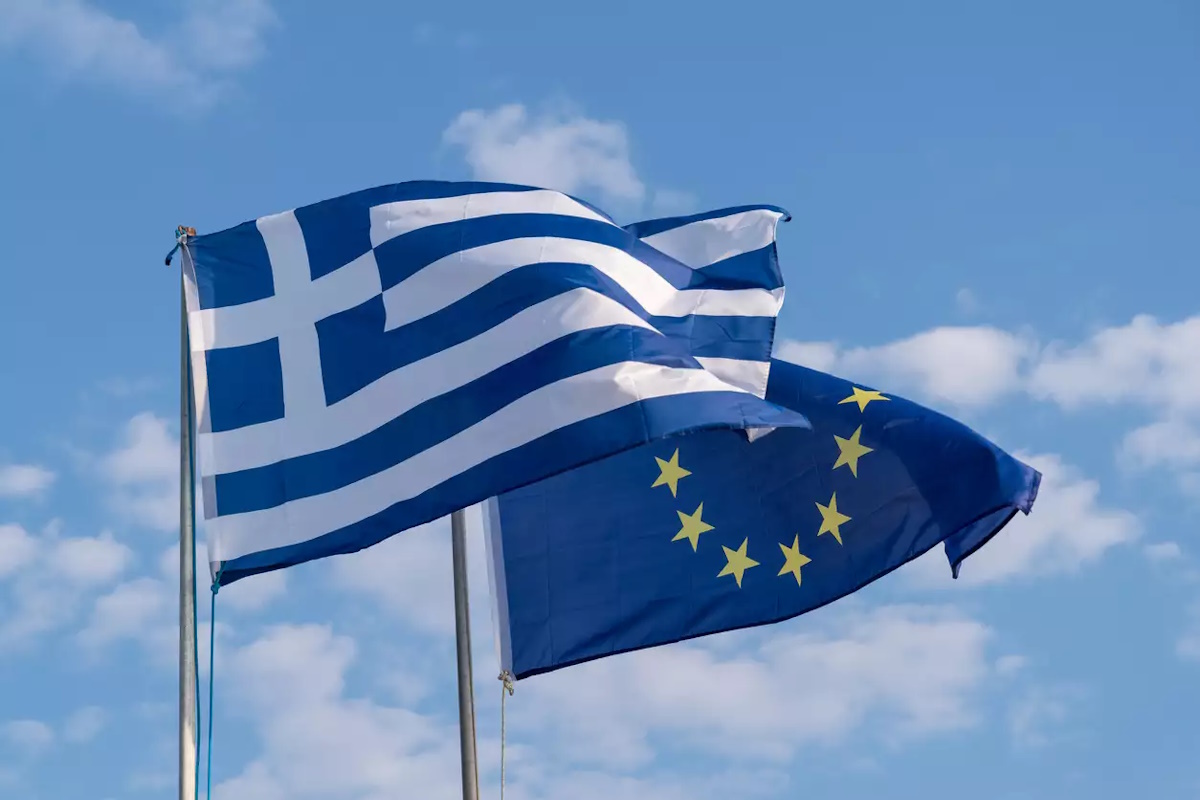 The national flag of Greece and the flag of the European Union.