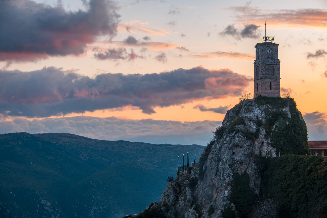 Panoramic photo of Arachova Clock Tower on the top of the rock at winter during sunset