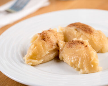 Turkish Flour Halva or Un Helvasi on white plate with cinnamon on top.