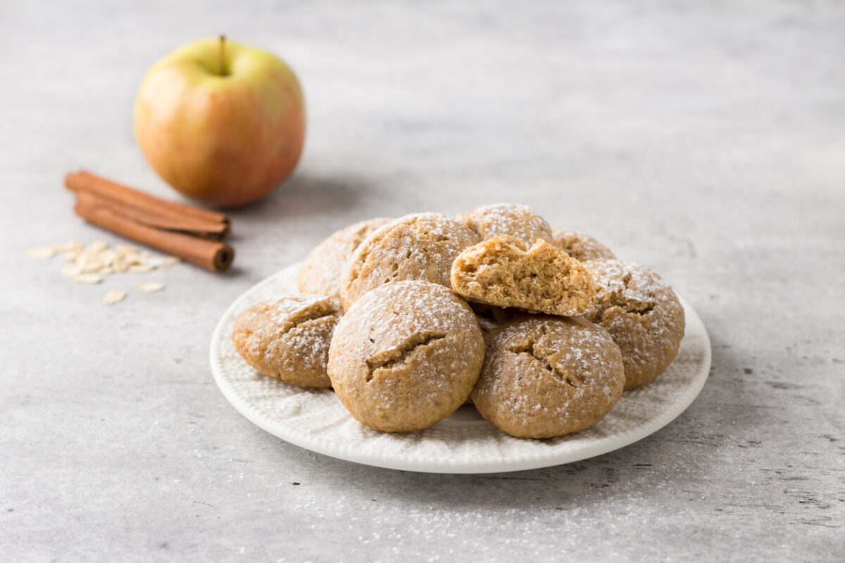 Steamed oatmeal cookies with apple and cinnamon sprinkled with powdered sugar on a light gray textured background. healthy homemade food