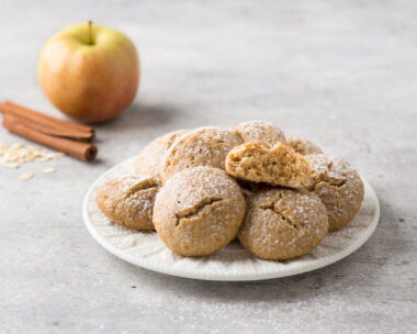 Steamed oatmeal cookies with apple and cinnamon sprinkled with powdered sugar on a light gray textured background. healthy homemade food