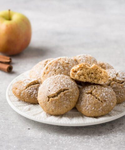 Steamed oatmeal cookies with apple and cinnamon sprinkled with powdered sugar on a light gray textured background. healthy homemade food