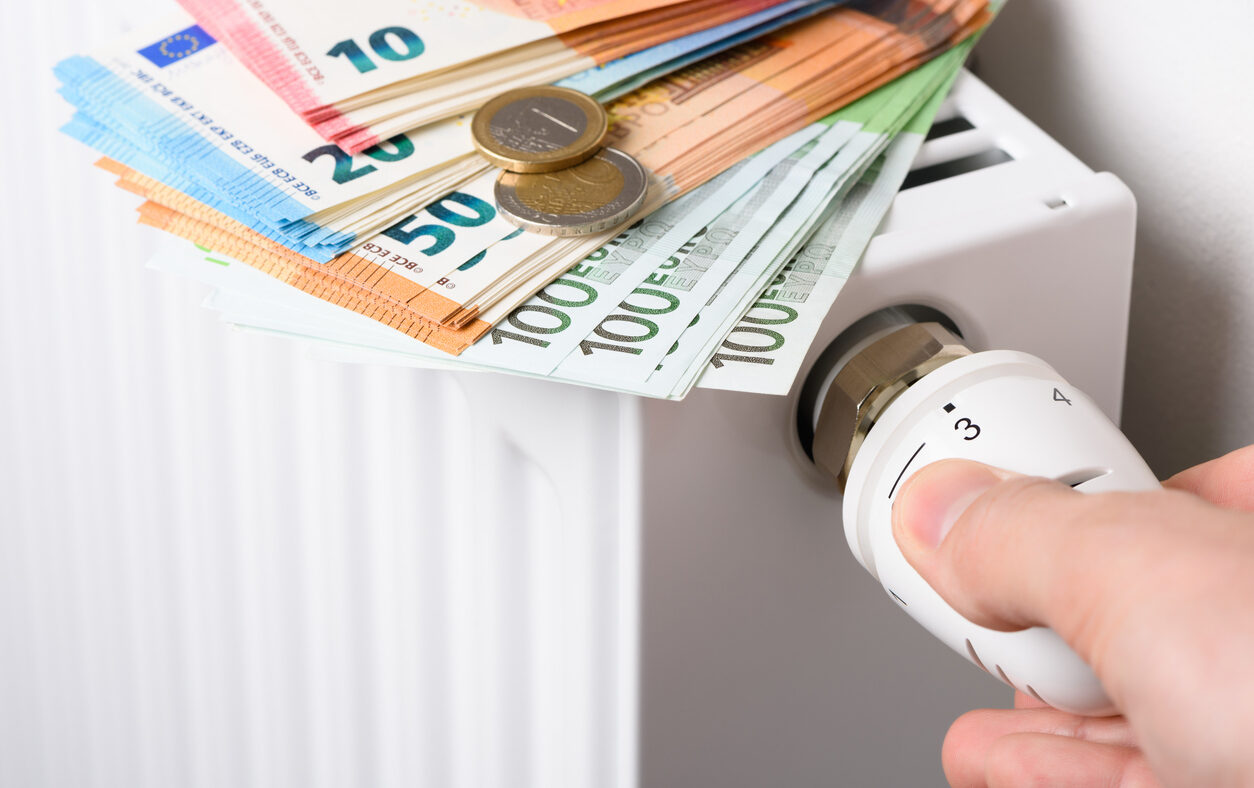 Hand adjusting the valve knob of heating room radiator temperature thermostat