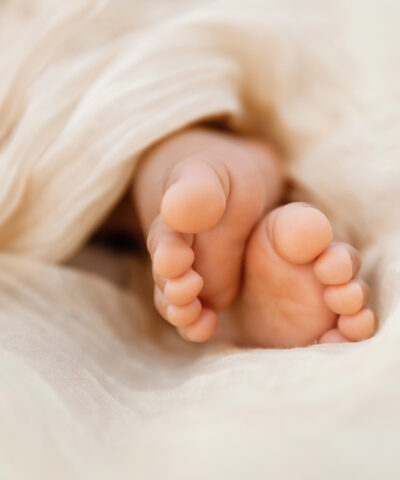 Newborn baby feet closeup on soft cream wrap in a selective focus - Image