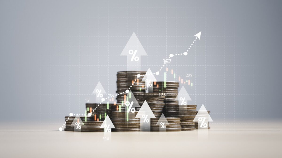 Heap of coins money with up arrow and stock market chart for financial banking increase interest rate or mortgage investment dividend from business growth concept.