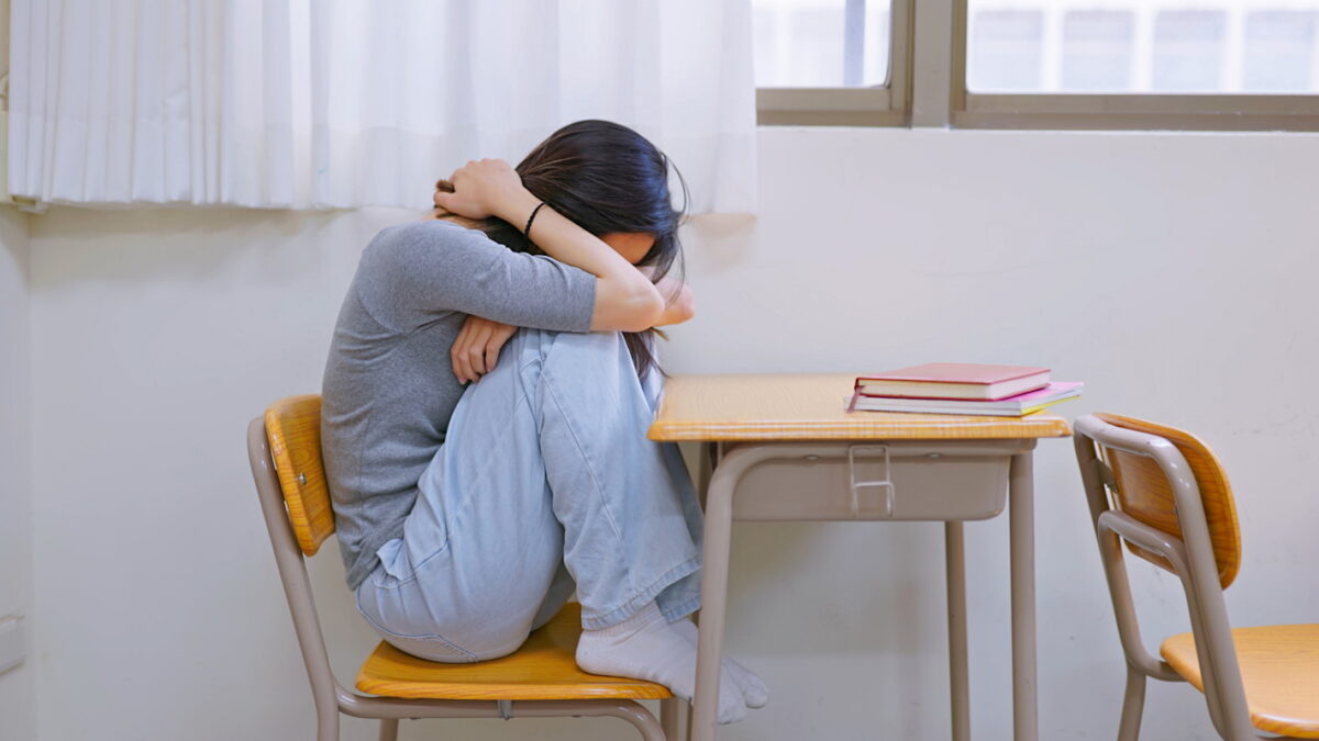 Asian female student is crying and depressed in classroom
