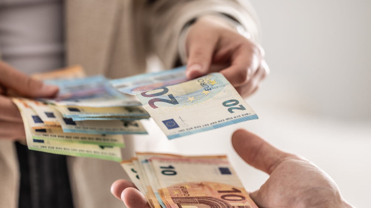 Businesswoman's hands exchanging euro banknotes, closeup shot.