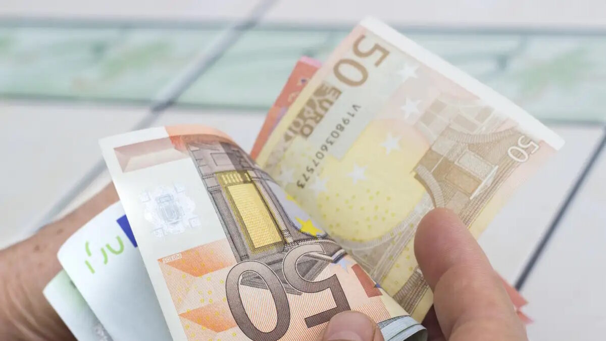 Close-up view of unrecognizable man counting money. Horizontal composition. Studio shot. Image developed from RAW format.