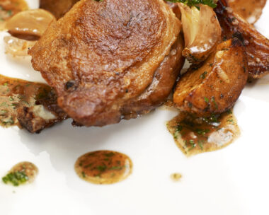 Turkey Steak with Herbs,Vegetables, Garlic and Red Sauce. Isolated on white plate.