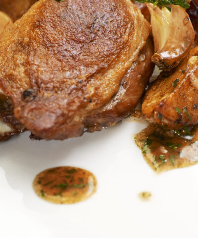 Turkey Steak with Herbs,Vegetables, Garlic and Red Sauce. Isolated on white plate.