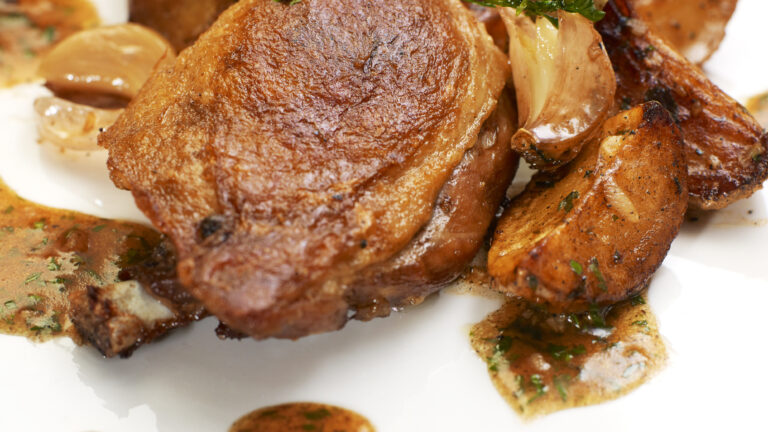 Turkey Steak with Herbs,Vegetables, Garlic and Red Sauce. Isolated on white plate.