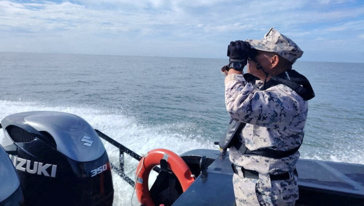 Μέλος της Μαλαισιανής Υπηρεσίας Θαλάσσιας Επιβολής του Νόμου αναζητά θύματα από ένα σκάφος από το Buthidaung της Μιανμάρ, το οποίο βυθίστηκε κοντά στα σύνορα Μαλαισίας-Ταϊλάνδης