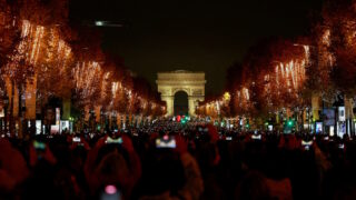 Πλήθος κόσμου απολαμβάνει τη φωταγώγηση κατά μήκος των Ηλυσίων Πεδίων, με την Αψίδα του Θριάμβου στο βάθος
