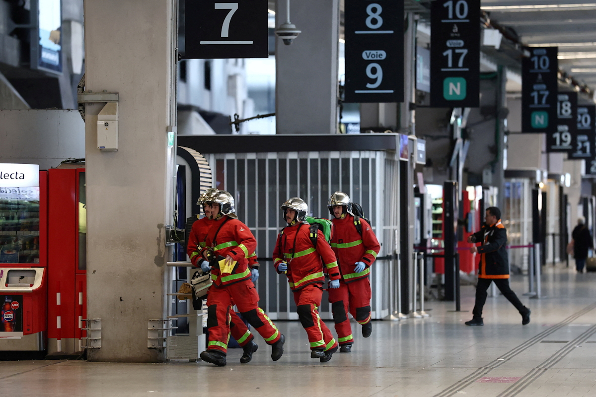 Γάλλοι πυροσβέστες τρέχουν μέσα από την αίθουσα του σιδηροδρομικού σταθμού Gare Montparnasse κατά τη διάρκεια της εκκένωσής του στο Παρίσι