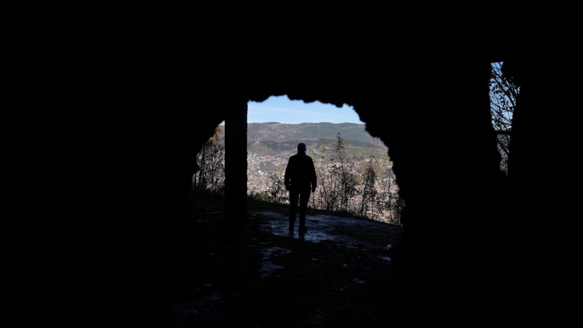 Βόσνιος κοιτάζει το Σεράγεβο από ένα κτήριο που καταστράφηκε κατά την διάρκεια του πολέμου