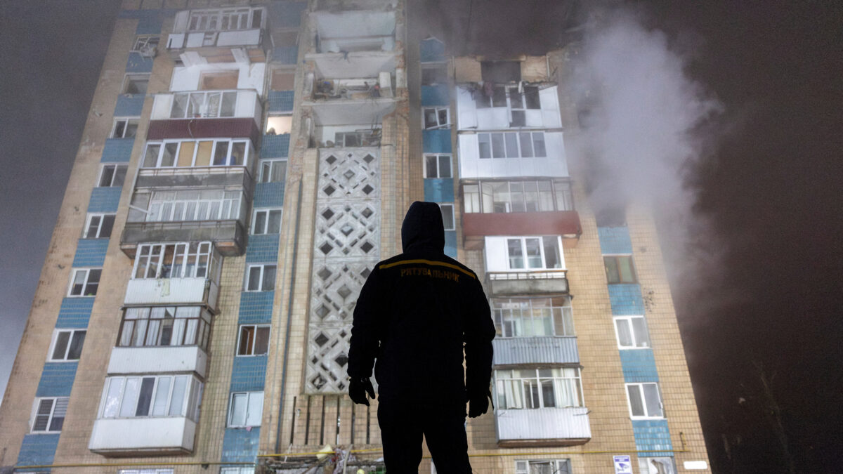 Άνδρας στέκεται μπροστά από ένα διαμέρισμα που βομβαρδίστηκε από τη Ρωσία στην Ουκρανία