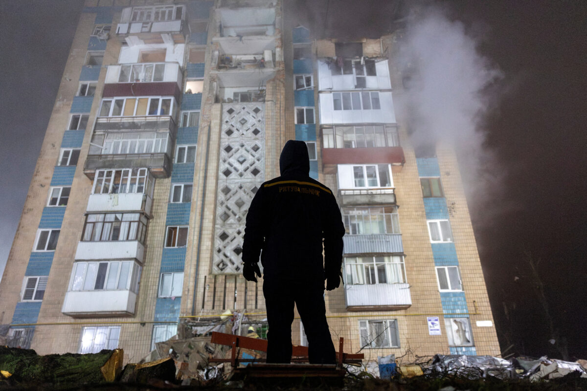 Άνδρας στέκεται μπροστά από ένα διαμέρισμα που βομβαρδίστηκε από τη Ρωσία στην Ουκρανία