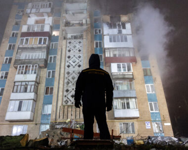 Άνδρας στέκεται μπροστά από ένα διαμέρισμα που βομβαρδίστηκε από τη Ρωσία στην Ουκρανία