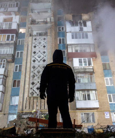 Άνδρας στέκεται μπροστά από ένα διαμέρισμα που βομβαρδίστηκε από τη Ρωσία στην Ουκρανία