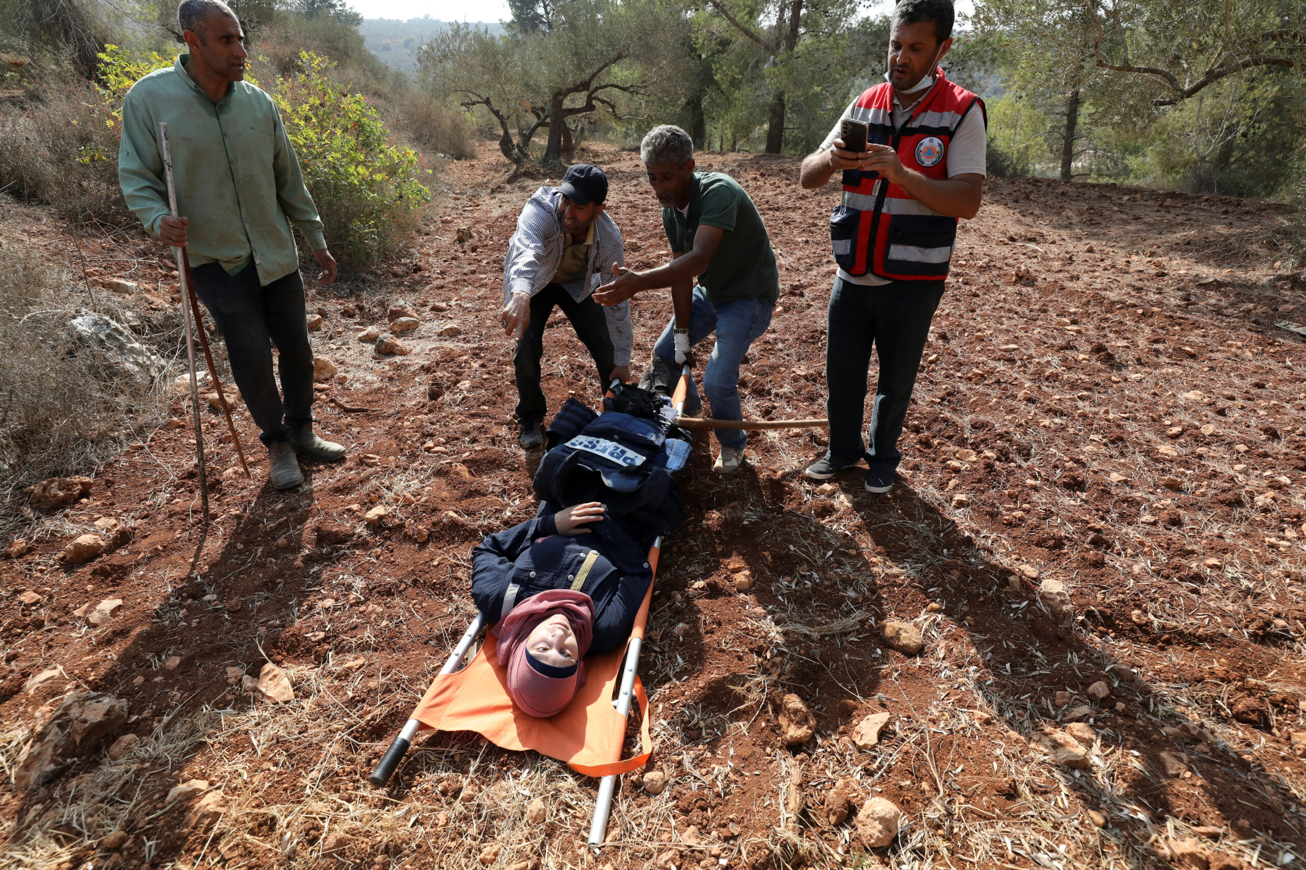 Ο σύμβουλος ασφαλείας του Reuters, Γκραντ Μπόουντεν, βοηθά τον φωτογράφο του Reuters, Ρανίν Σαουάφτα, μετά από επίθεση ισραηλινών εποίκων