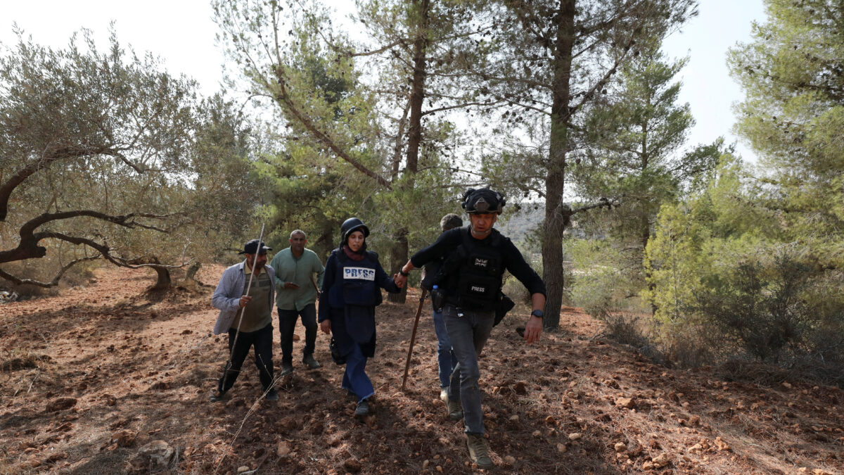 Ο σύμβουλος ασφαλείας του Reuters, Γκραντ Μπόουντεν, βοηθά τον φωτογράφο του Reuters, Ρανίν Σαουάφτα, μετά από επίθεση ισραηλινών εποίκων