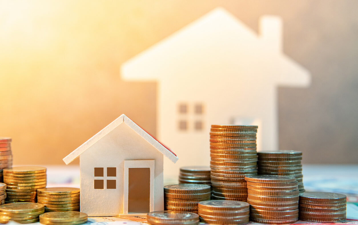 Real estate or property investment. Home mortgage loan rate. Saving money for retirement concept. Coin stack on international banknotes with house model on table. Business growth background