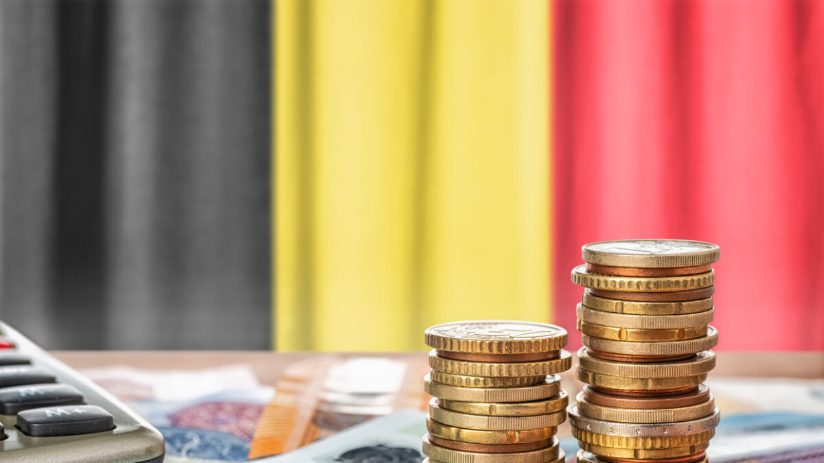 Euro banknotes and coins in front of the national flag of Belgium