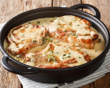 boneless pork chops served in creamy wine sauce with herbs close-up in a pan on the table. horizontal