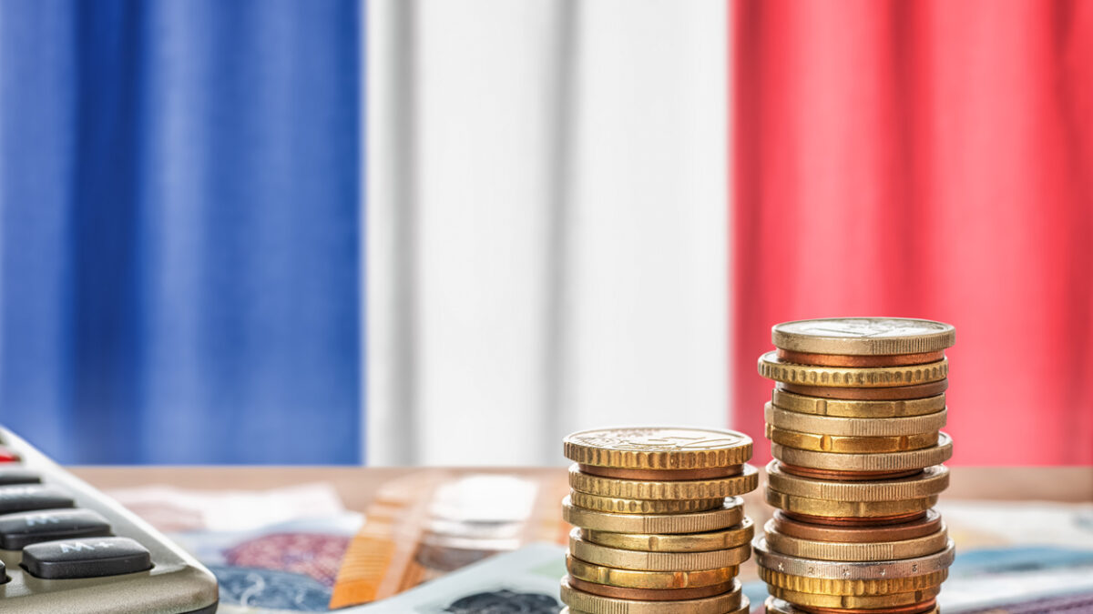 Euro banknotes and coins in front of the national flag of France