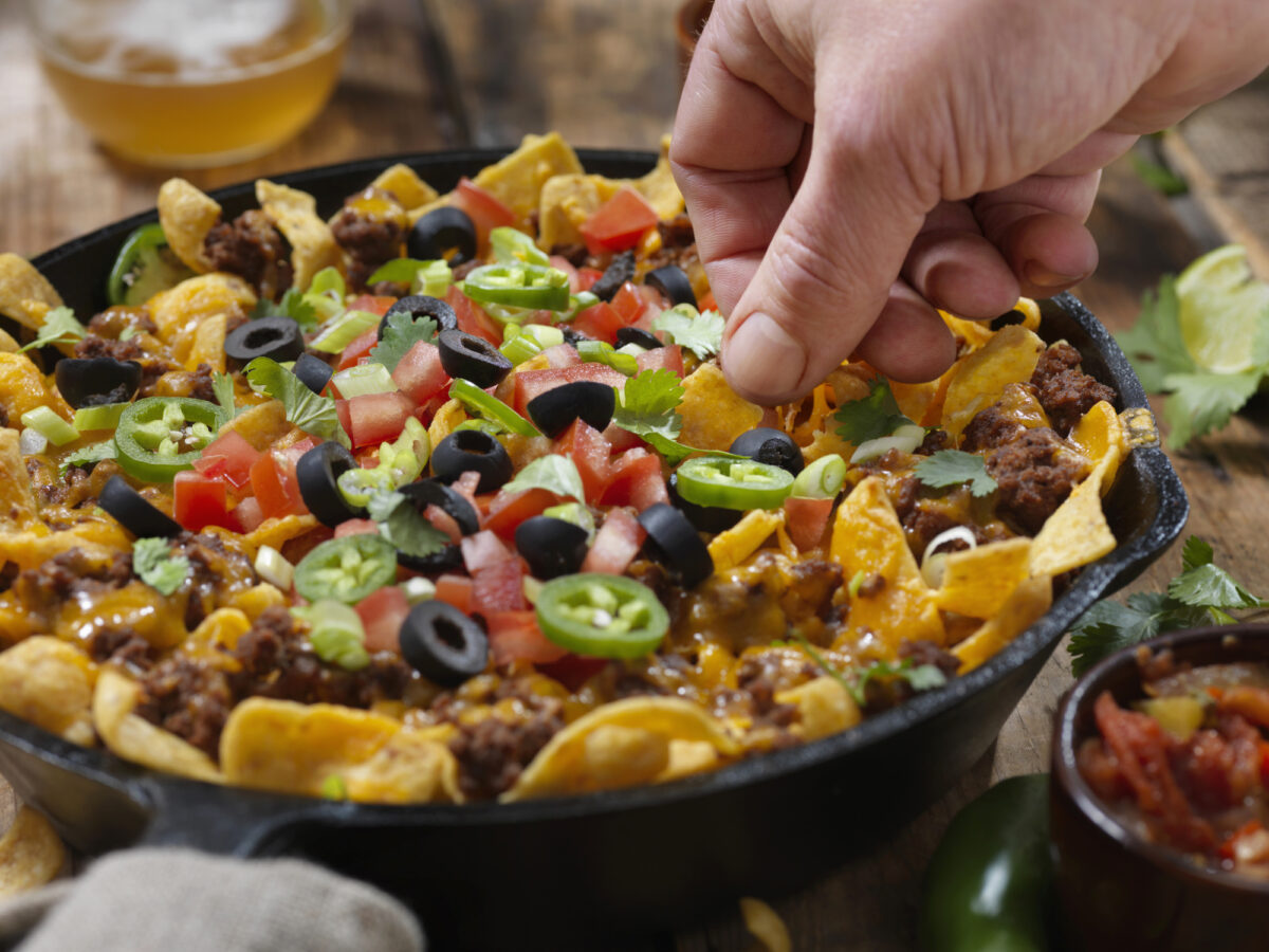 Baked Frito Pie (Chili Corn Chip Nachos) with Black Olives, Tomatoes, Green Onions, Jalapenos, Salsa, Guacamole and Sour Cream