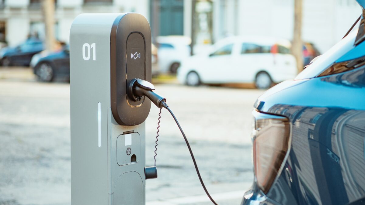Electric cars on chargers on modern public parking