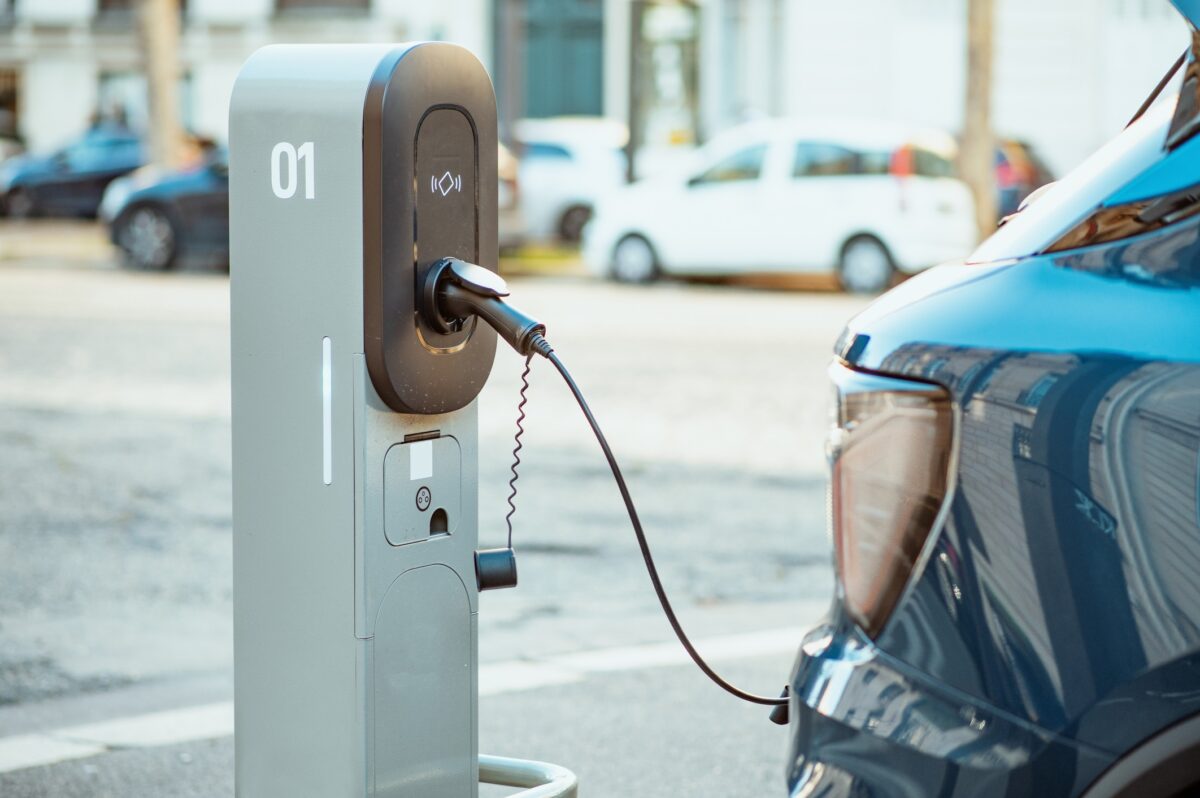 Electric cars on chargers on modern public parking