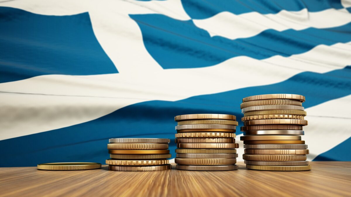 Rising stack of coins with Greek flag in the background. Economy, finance, interest rates concept.